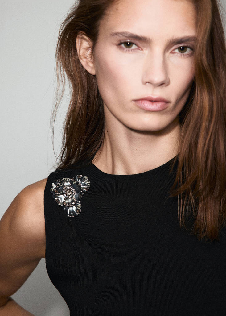 Strikket top med metalblomst
