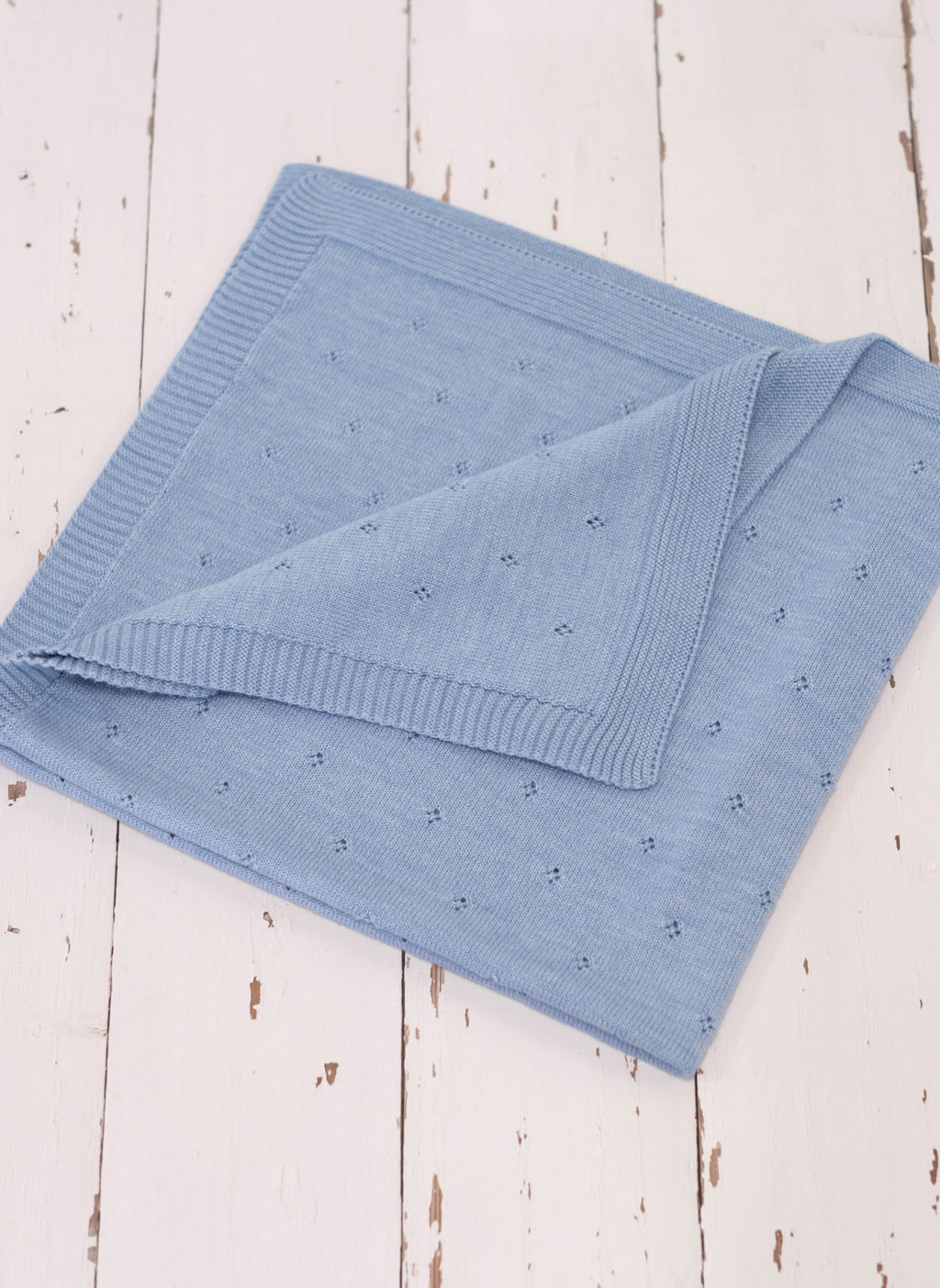 La Manufacture De Layette – Couverture Ajourée En Laine - Bleu Clair, couverture bébé en maille de coton bleu ciel, pliée sur fond blanc