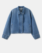 Chaqueta vaquera de algodón de color azul claro, de corte recto y corto con cuello clásico, manga larga ligeramente amplia y discretos bolsillos laterales.