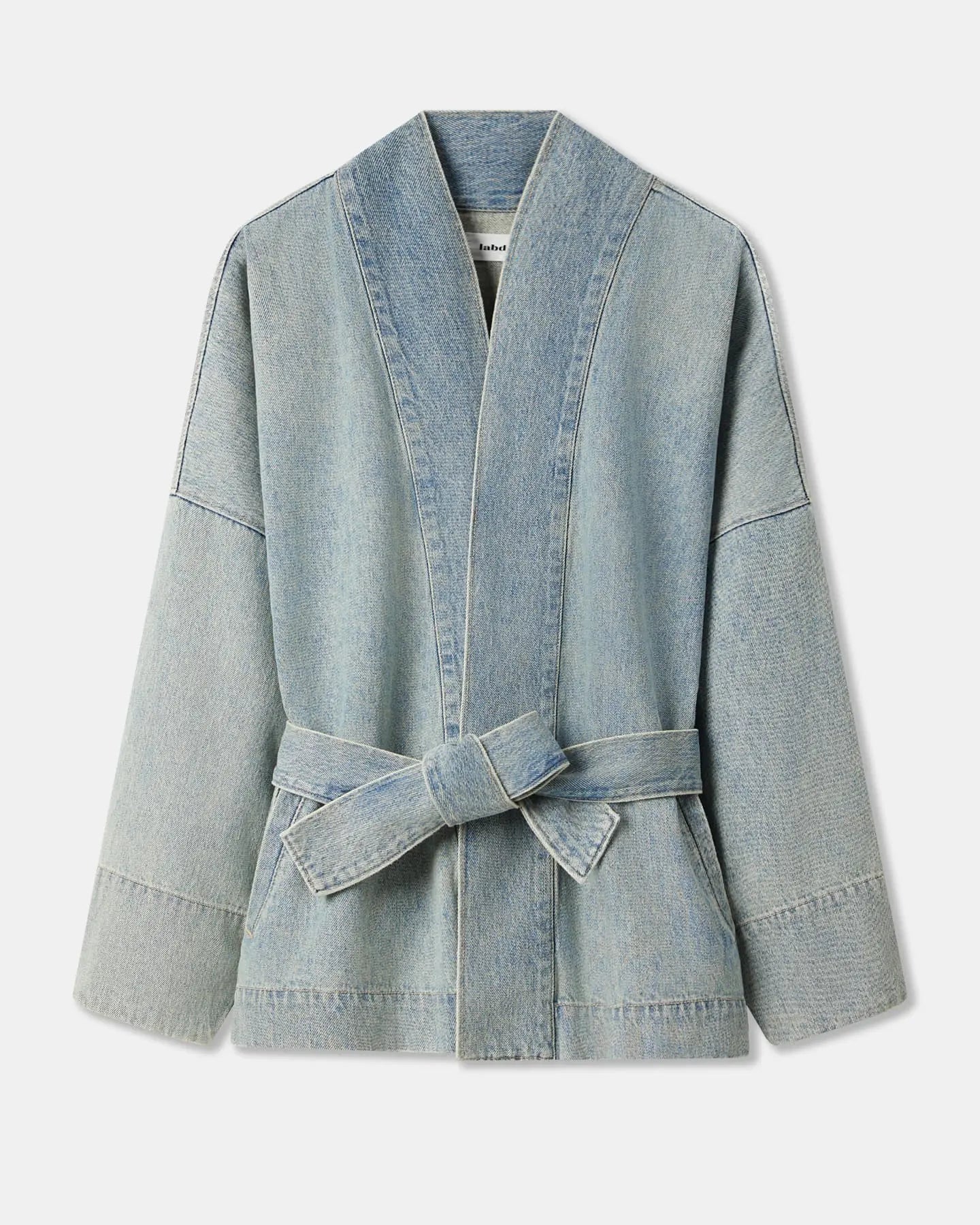 Veste en denim bleu clair effet délavé, coupe droite avec manches larges et ceinture à nouer, conçue pour un style décontracté et adaptable.