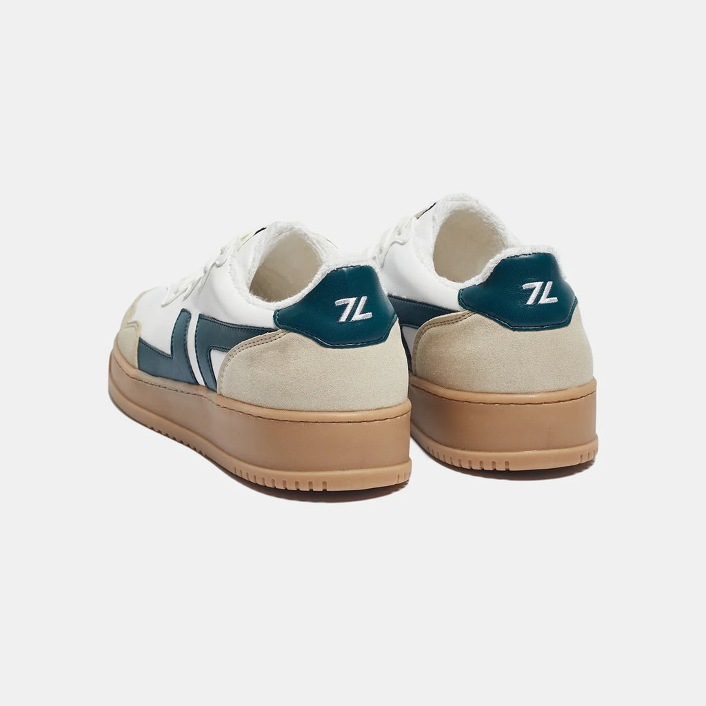 Zapatillas veganas cómodas con suela gruesa. La zapatilla es blanca con el logotipo verde