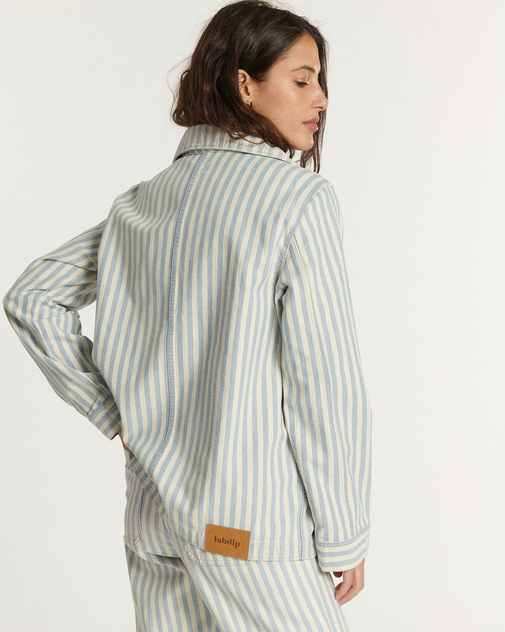 Jean en denim coton indigo clair avec rayures blanches, coupe droite et ajustée, offrant une silhouette confortable et élégante pour femme.