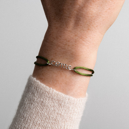 Detailed view of hand-shaped silver wire forming a first name