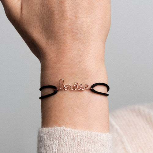 Close up of hand shaped rolled rose gold wire