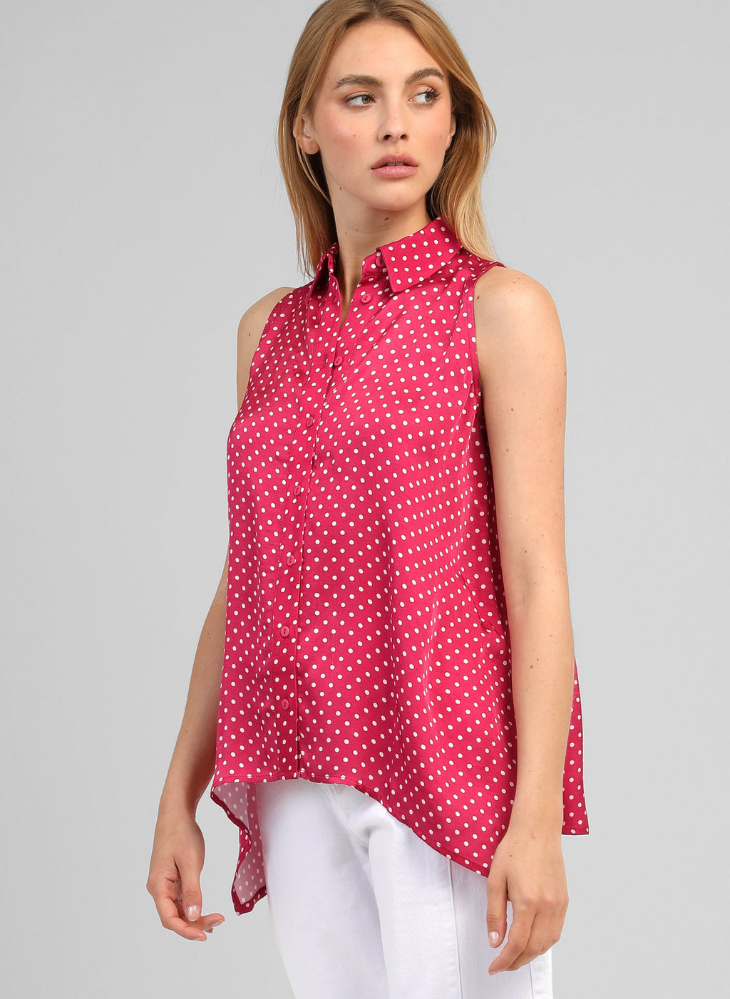 An'ge – Camicia Klarissa Doriva Framboise, camicetta smanicata fucsia a pois bianchi, indossata da una donna bionda