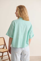 Chemise verte décontractée à manches courtes, coupe large et poches, parfaite pour les journées ensoleillées