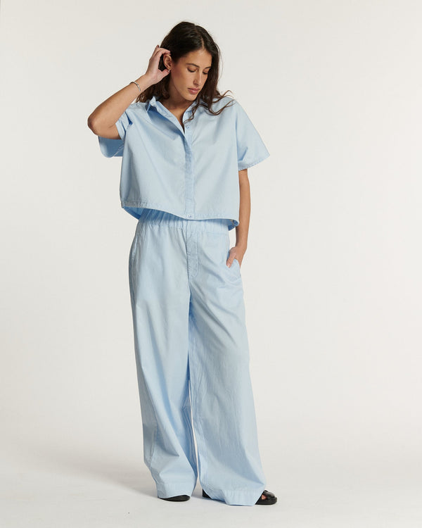 Pantalón ancho de popelina celeste claro, corte fluido y relajado apto para todo tipo de cuerpos para un estilo veraniego femenino y cómodo.