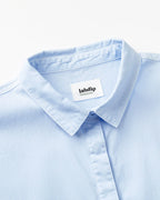 Col chemise bleu clair en popeline légère, tissu doux et respirant idéal pour un style estival élégant et confortable.