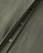 Khaki cotton poplin fabric with sober black buttonholes, showing the quality and finesse of the material, ideal for light and elegant pants.