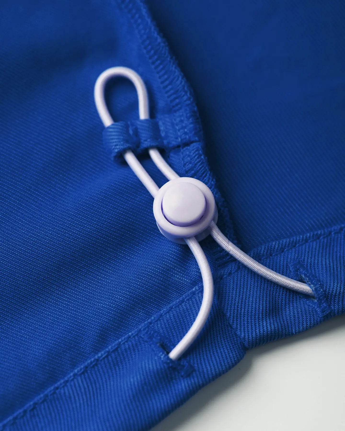 Detalle de jeans azul eléctrico en material Tencel con cordón ajustable para un ajuste perfecto, destacando un corte adaptado a las formas del cuerpo femenino.