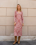 Michonet – Jurk Chevron Nude, model in een lange jurk met rood-witte geometrische motieven
