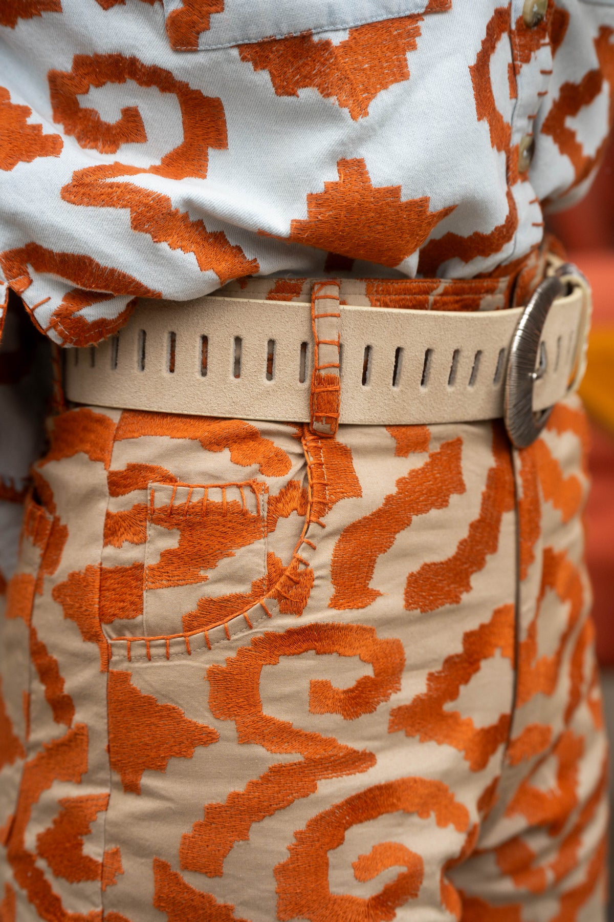 Michonet – Pantaloni Etnico Orange, pantaloni e camicia a motivi arancioni e beige, indossati con cintura