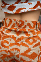 Michonet – Pantaloni Etnico Orange, capo indossato di schiena, motivo arancione su sfondo beige, dettaglio cucitura