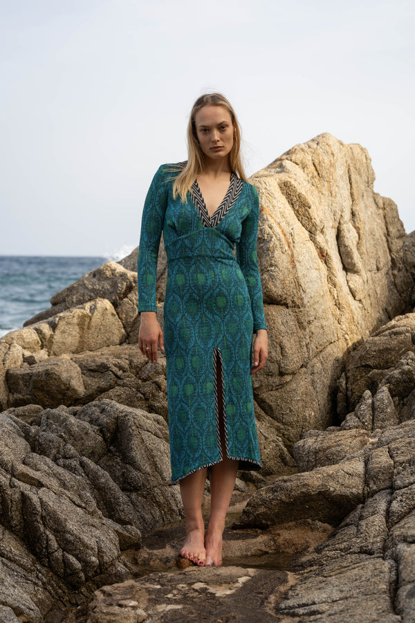 Michonet – Robe Bohemian Deluxe, mannequin portant une robe longue verte à motifs sur des rochers