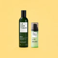 Lazartigue – Repair Duo (Shampoo + Restructuring Concentrate), two green cosmetic bottles on a plain yellow background