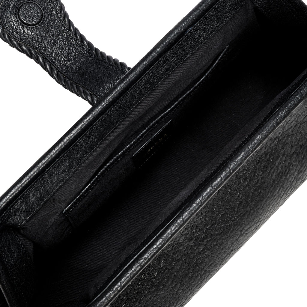 Close-up of a black leather bag with a white interior and card slots