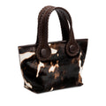Dark brown and cream cow print pattern small tote bag with dark brown rope handles on a white background.