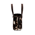 Dark brown and cream cow print pattern tote bag with open dark brown rope handles on a white background, shown from the side.