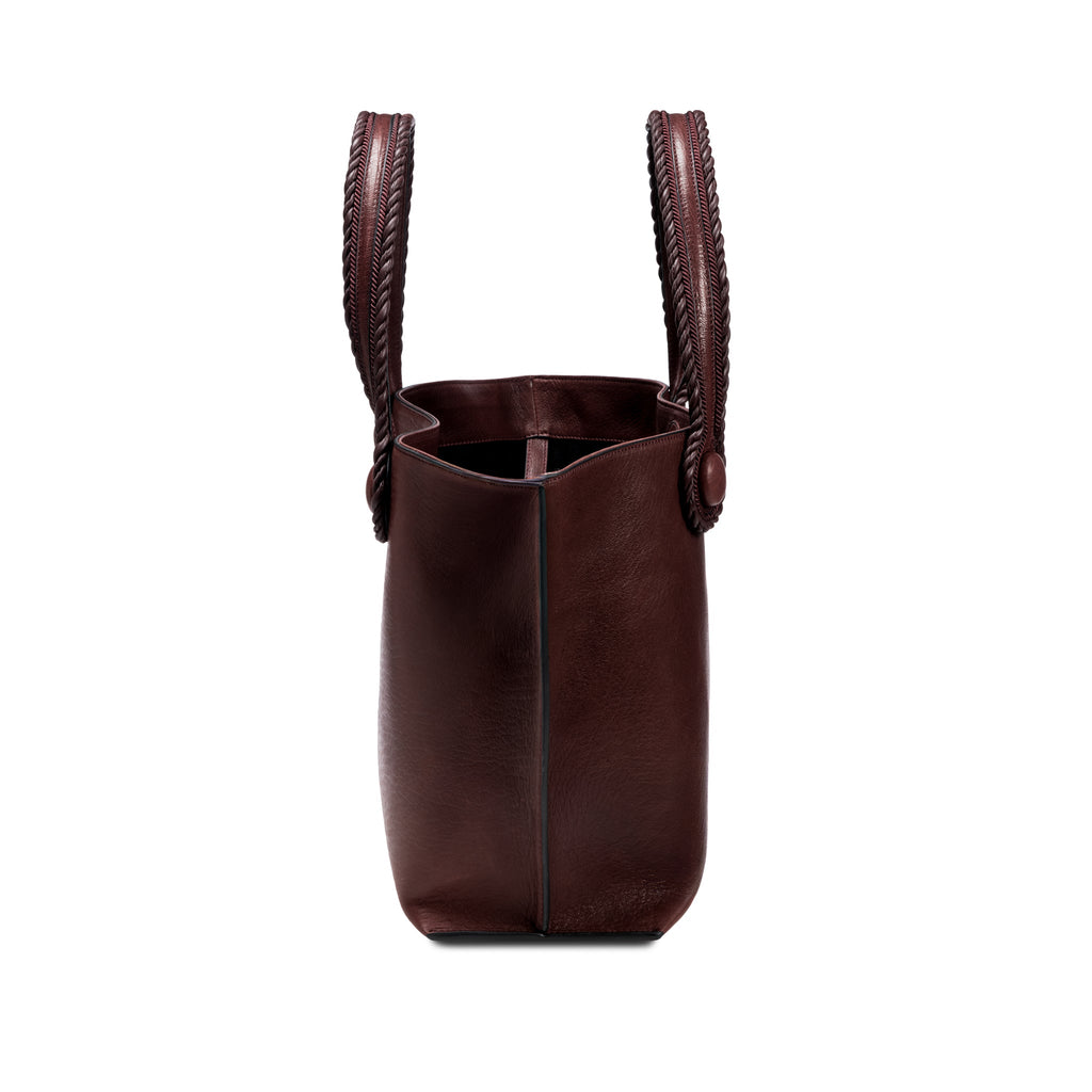 Burgundy leather in a shade of dark cherry tote bag with  an open rope handles on a white background, shown from the side.