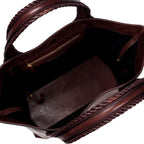 Close-up of a burgundy leather in a shade of dark cherry bag with a same tone interior. It has an inner pocket with zip and keys strap.