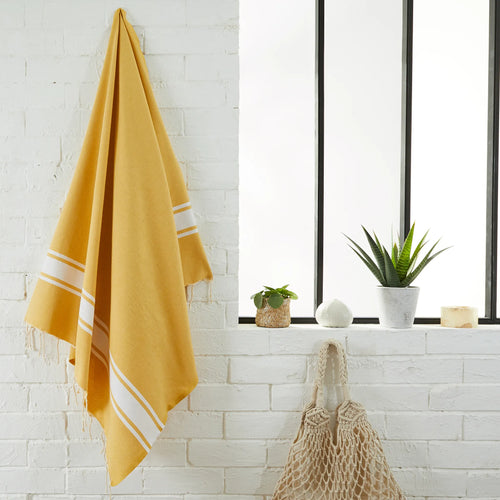 Woman using a Mustard Yellow Classic Fouta - BY FOUTAS