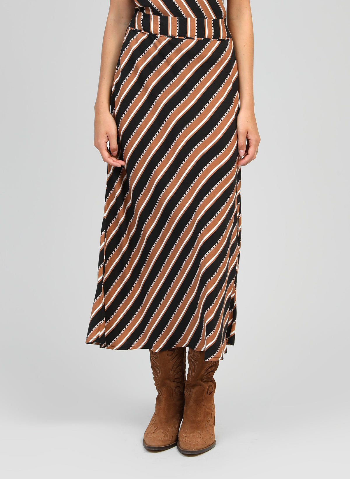 An'ge – Jupe Midi Gania Velia Camel, jupe longue marron, noire et blanche à rayures diagonales portée par un mannequin