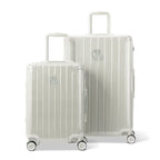 Deux valises rigides GYL Intemporelle sable, format cabine et soute, avec poignée trolley déployée. #couleur_sable