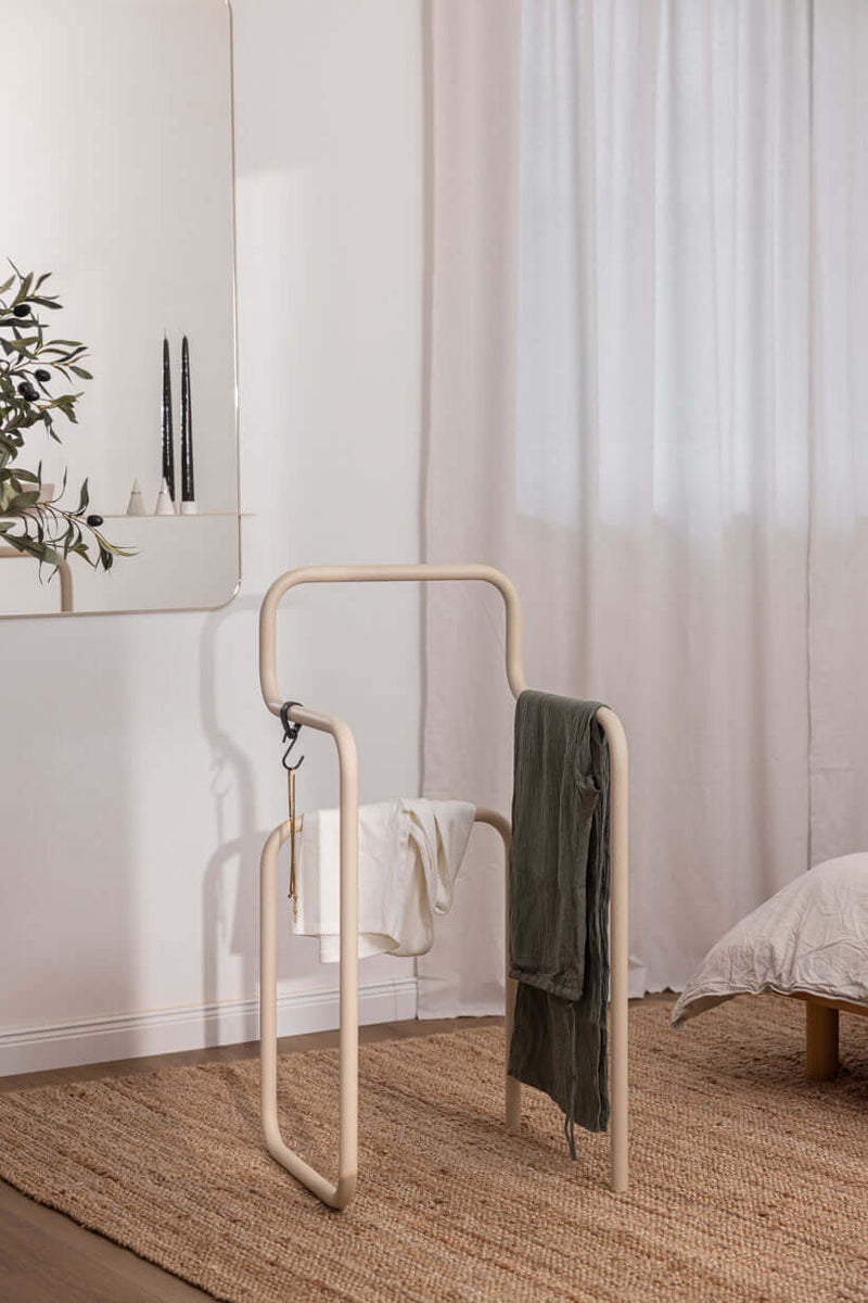 Minimalista Herrendiener JAMES mit Kleidungsstücken en un moderno Schlafzimmer