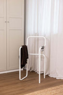 Minimalista Herrendiener JAMES mit braunem Tuch in einem modernen Schlafzimmer.