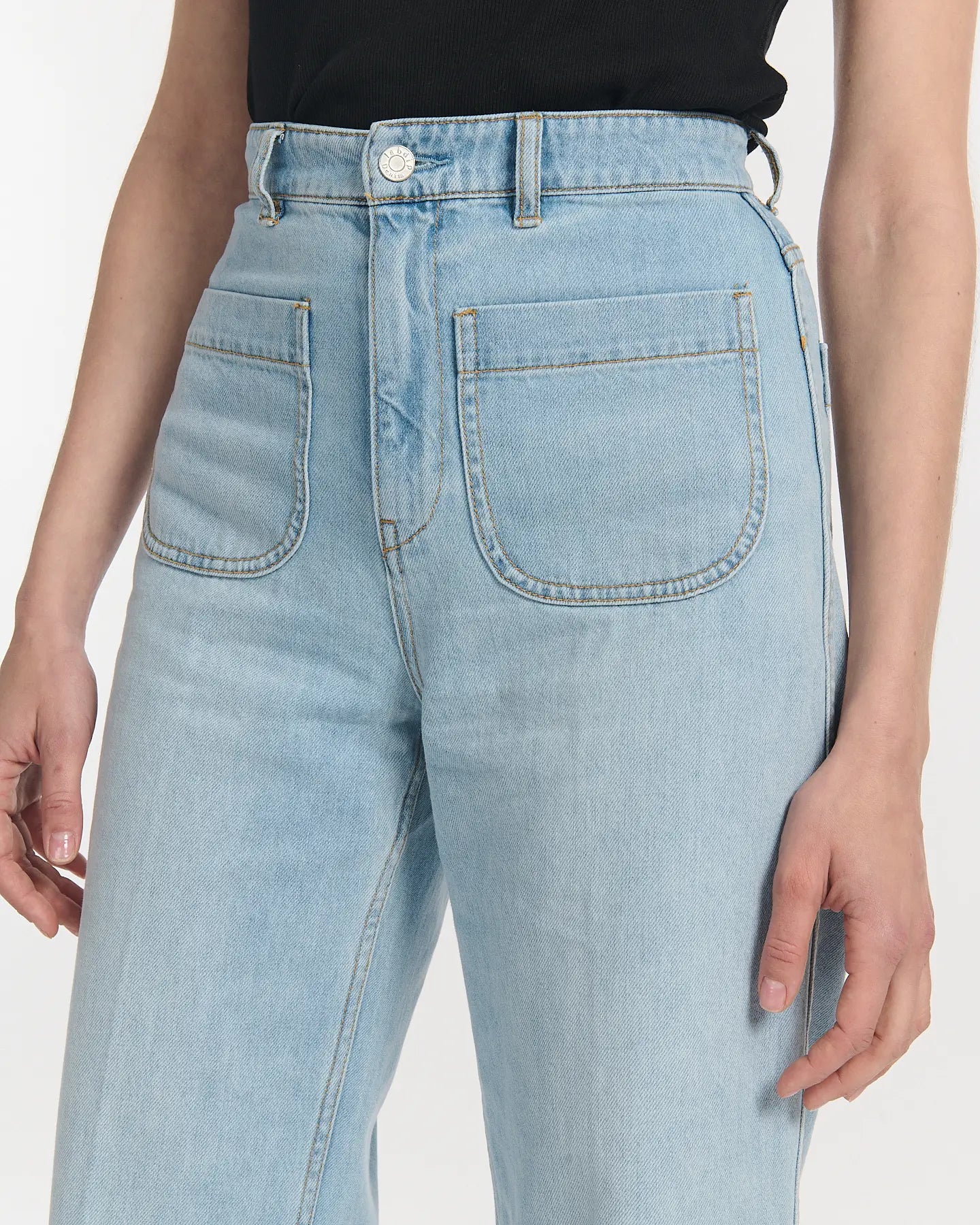 Women's jeans in 100% cotton denim in light blue, straight cut with high waist and front patch pockets, offering a comfortable and elegant silhouette.