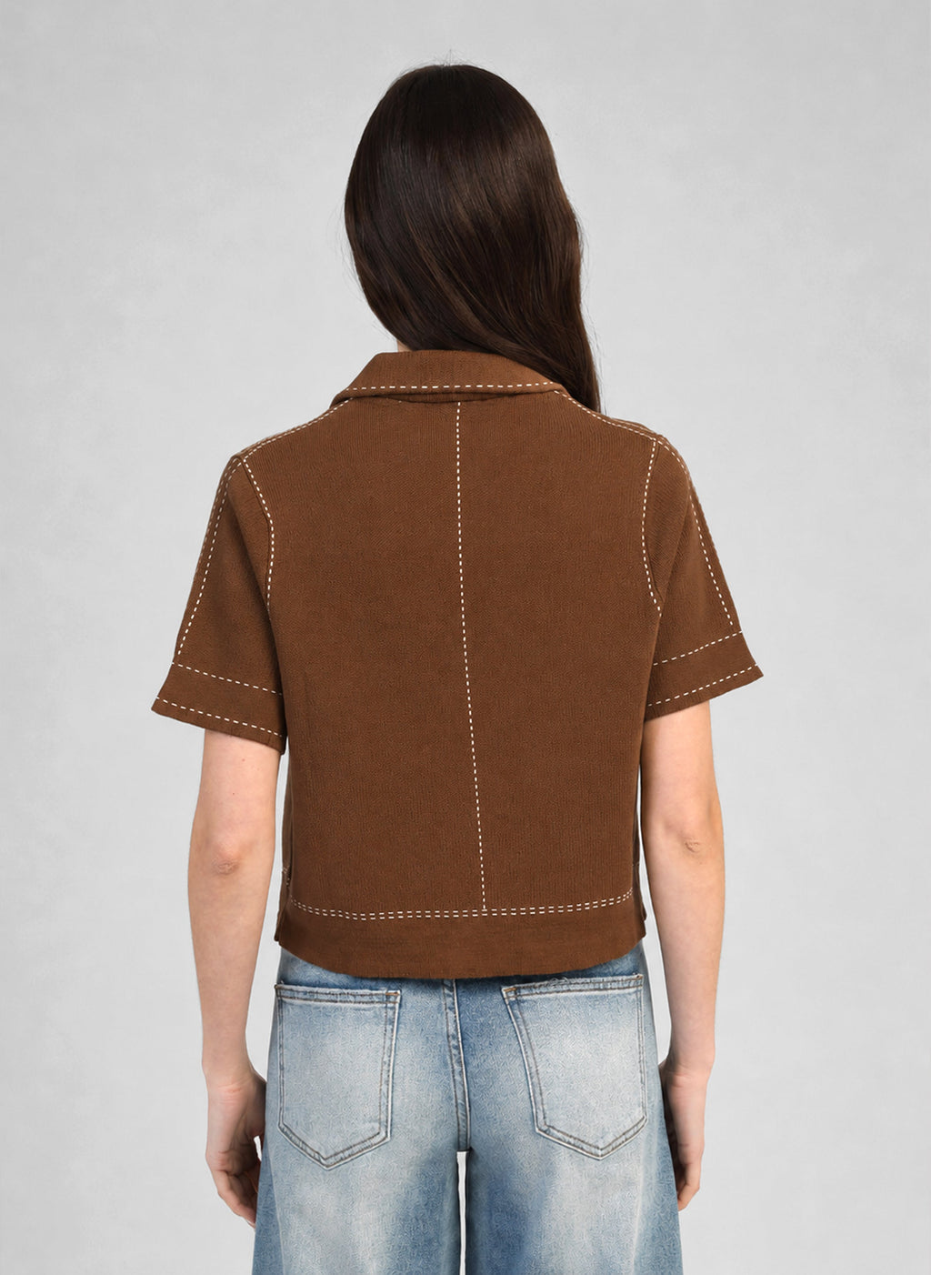 An'ge – Gilet Lebilly Marron, model van achteren draagt een bruine top met korte mouwen en een jeans