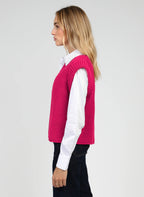 An'ge – Gilet Legringo Fushia, vrouwelijk model in profiel gekleed in een fuchsiazwevende mouwloze trui