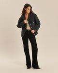 Jean pour femme en denim noir charbon, coupe bootcut ajustée et légèrement évasée, avec une matière confortable et épurée qui s’adapte à toutes les morphologies.