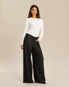 Jean femme en denim gris foncé, coupe large et fluide, tissu en coton épais, ajusté à la taille et ample sur les jambes pour un confort optimal.