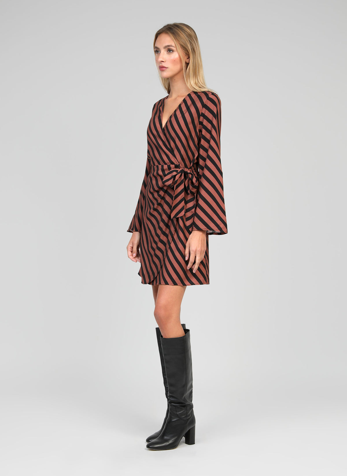An'ge – Robe Courte Metaly Stipe Chocolat, mannequin portant une robe portefeuille marron à rayures noires, de profil