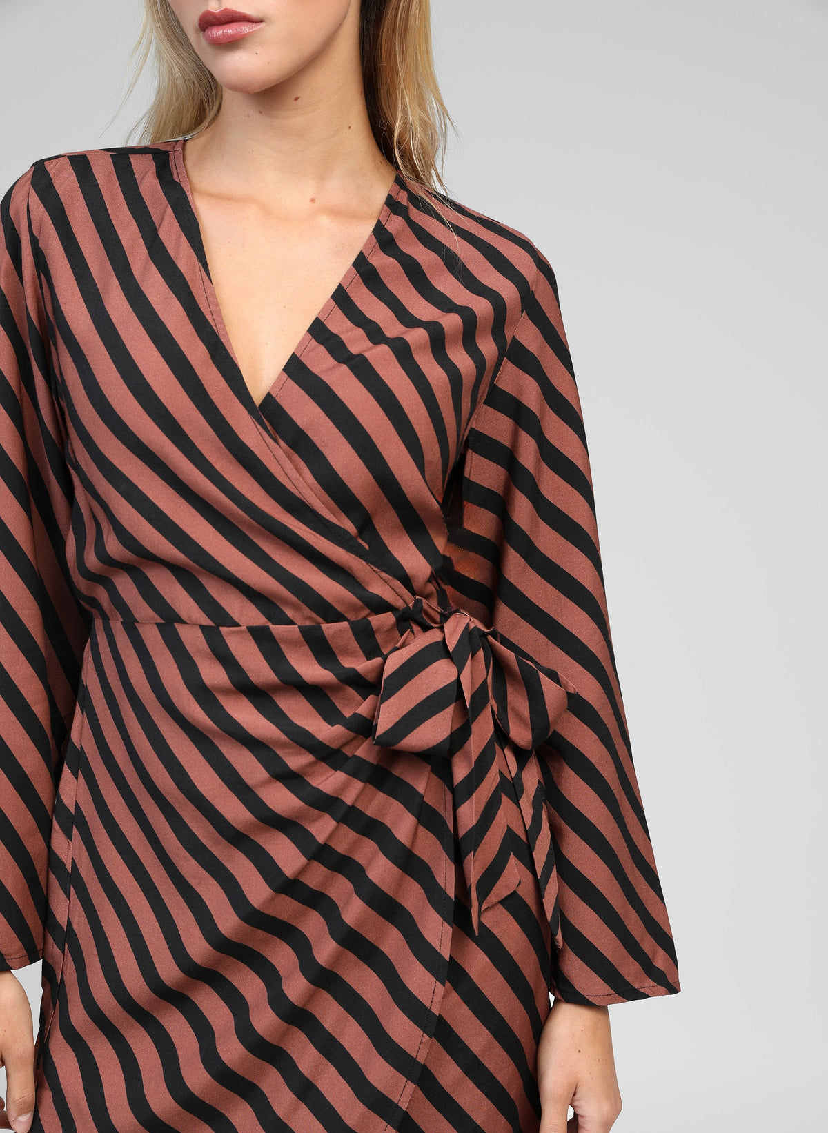 An'ge – Robe Courte Metaly Stipe Chocolat, mannequin portant une robe portefeuille marron et noire à rayures diagonales