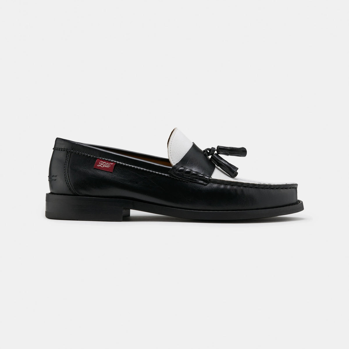 mocasines con borlas en blanco y negro