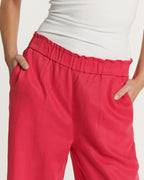 Women's jeans in soft, flowing cherry-colored fabric, straight cut with gathered elastic waist for a comfortable fit suitable for all body types.