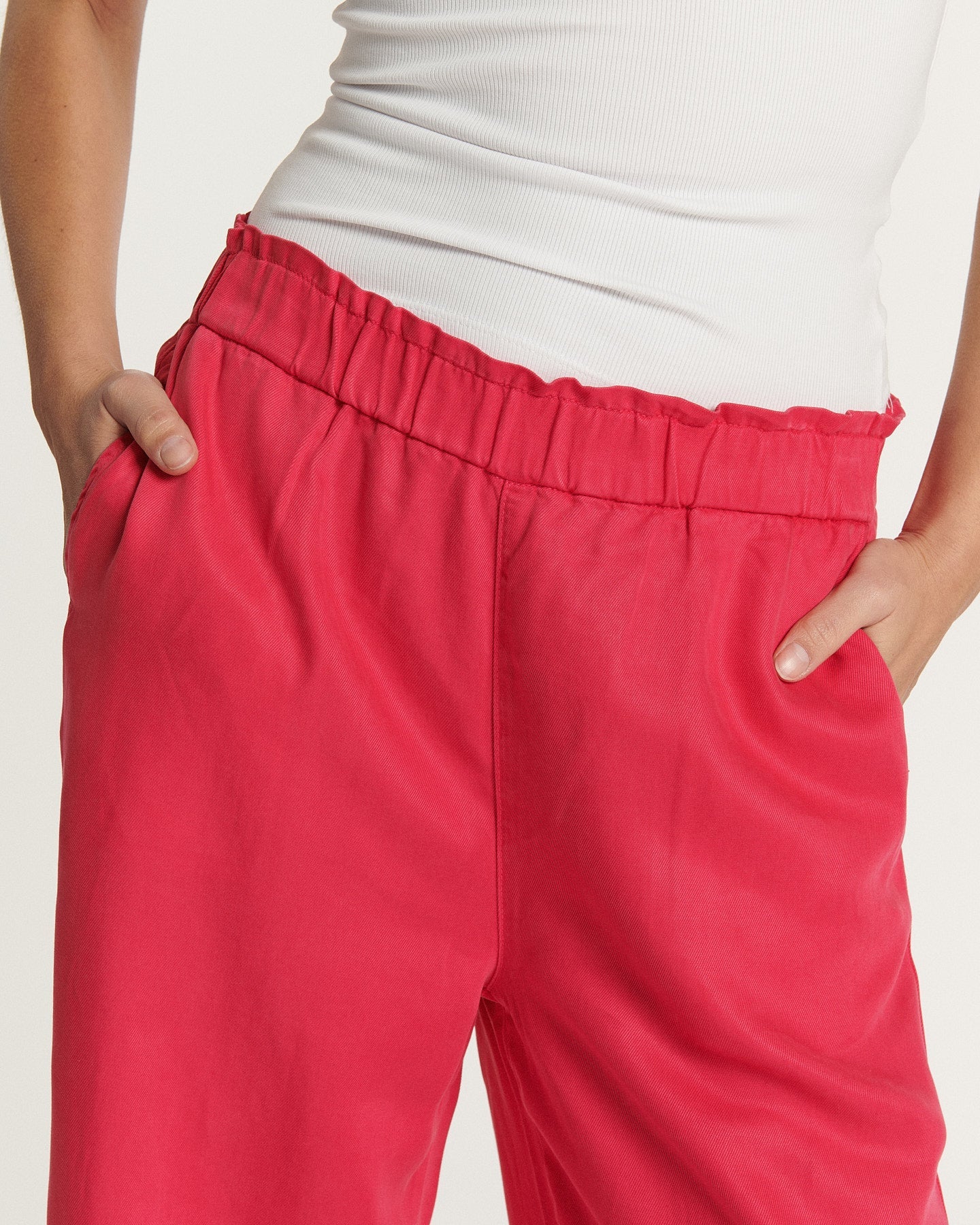 Women's jeans in soft, flowing cherry-colored fabric, straight cut with gathered elastic waist for a comfortable fit suitable for all body types.