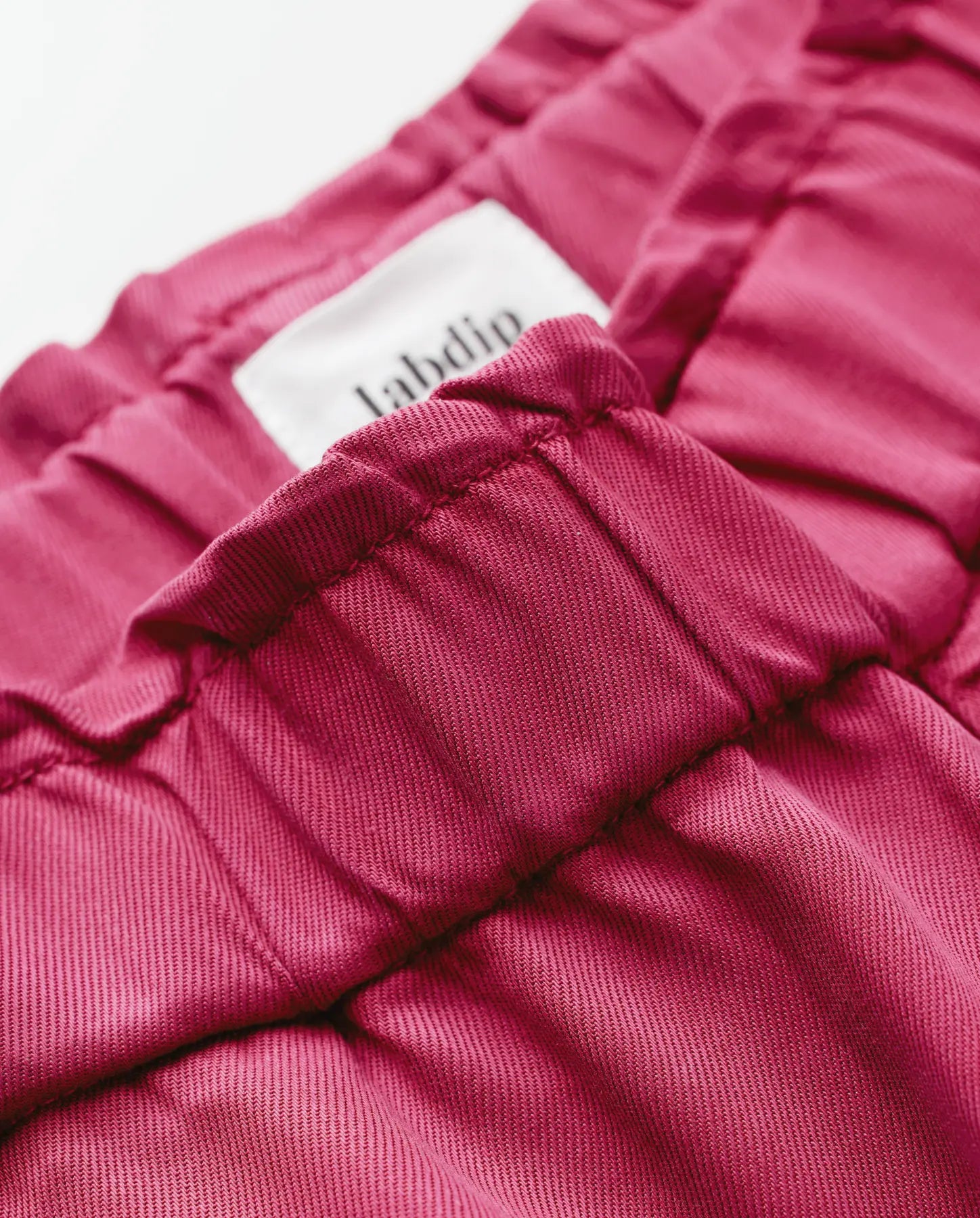 Women's jeans in cherry red Tencel fabric, fitted cut with elastic waist, soft and light material ideal for comfortable and elegant pants.