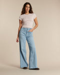 Jean femme en denim bleu clair, coupe flare ample, taille haute, matière en coton souple pour un confort optimal adapté à toutes les morphologies.