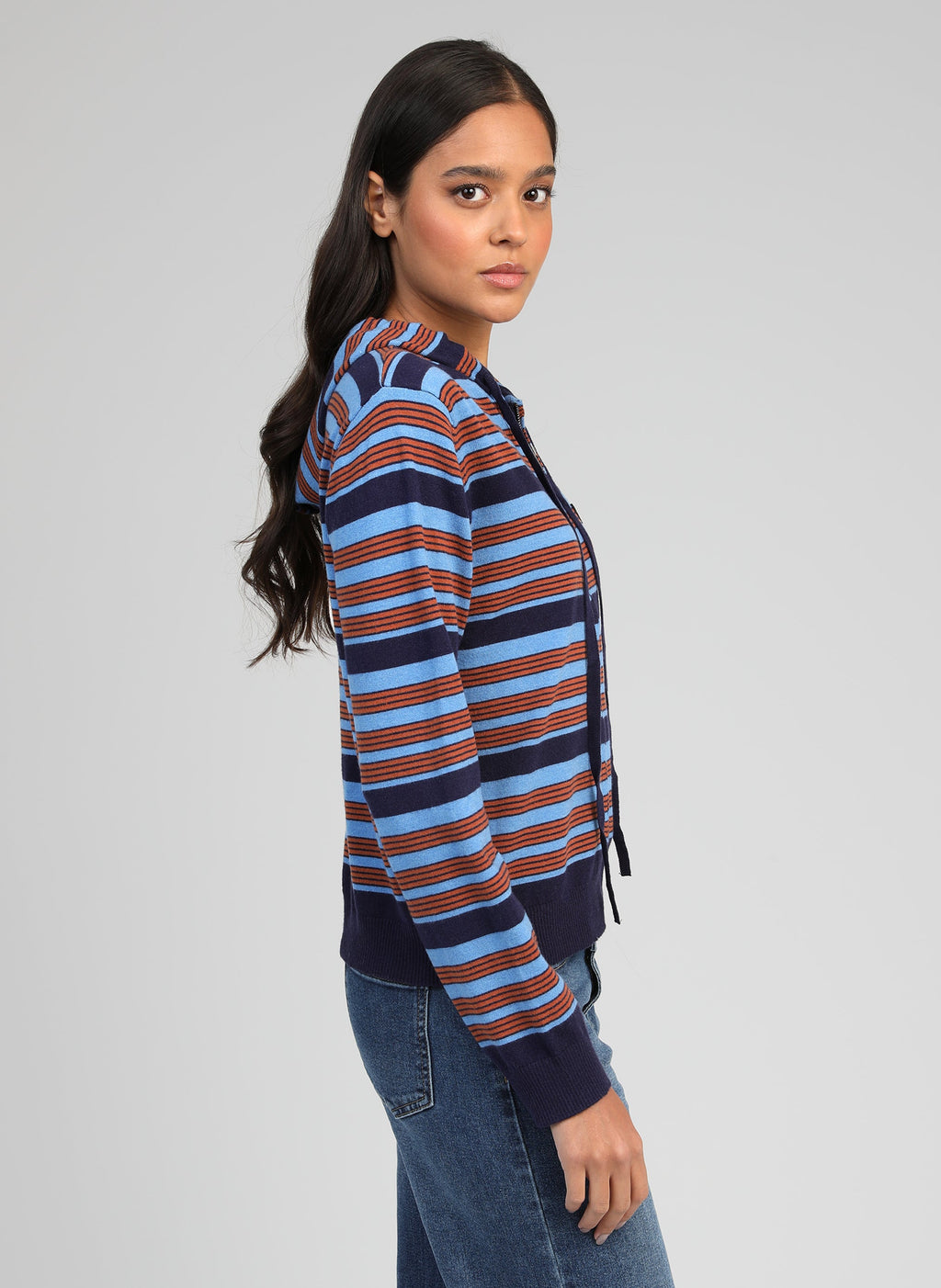 An'ge – Cardigan Norami Marine, modella con maglione con cappuccio a righe blu e marroni, vista di profilo