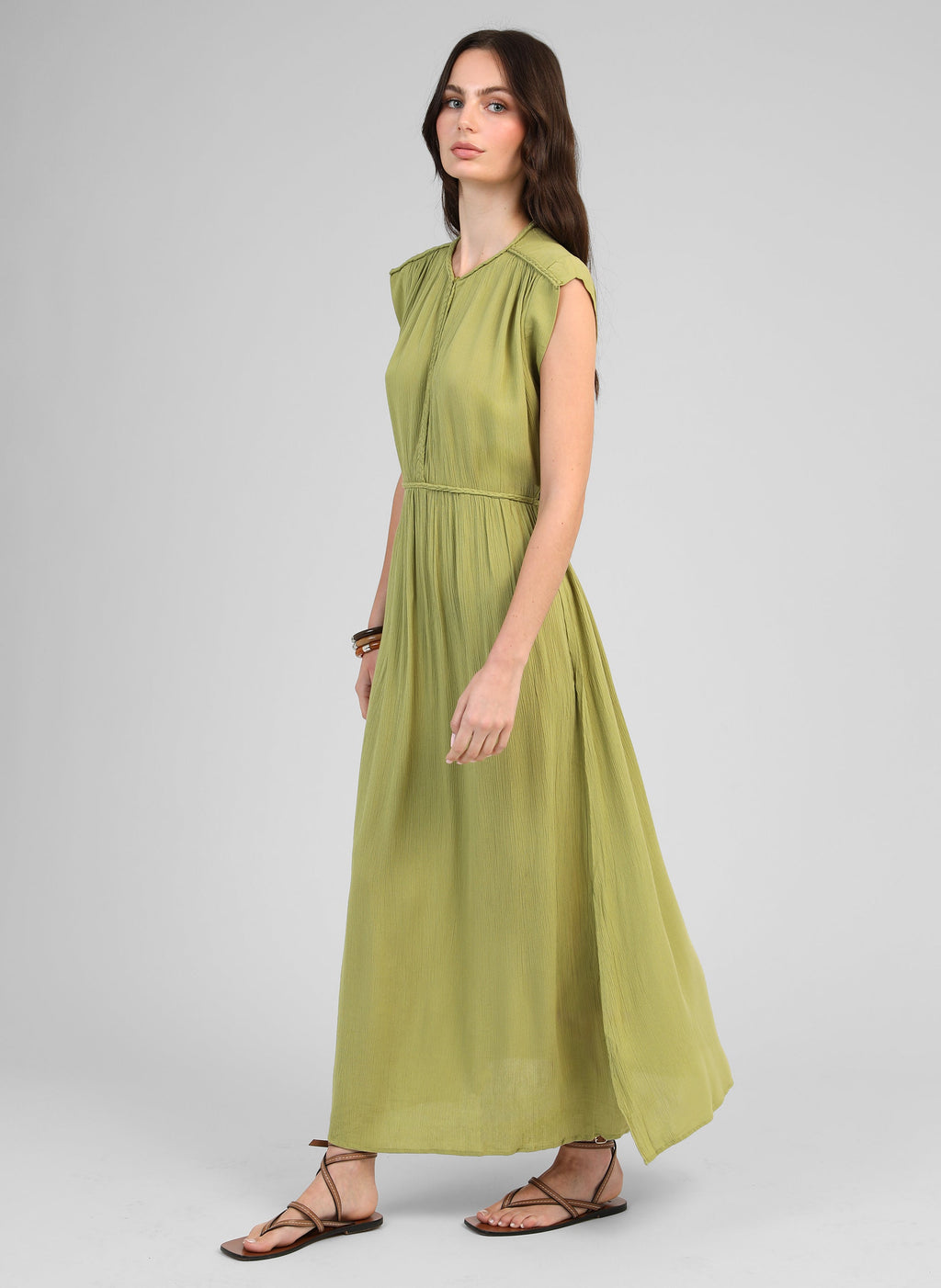 An'ge – Maxikleid Owestina Tilleul, Model trägt ein langes grünes Kleid, Profilansicht