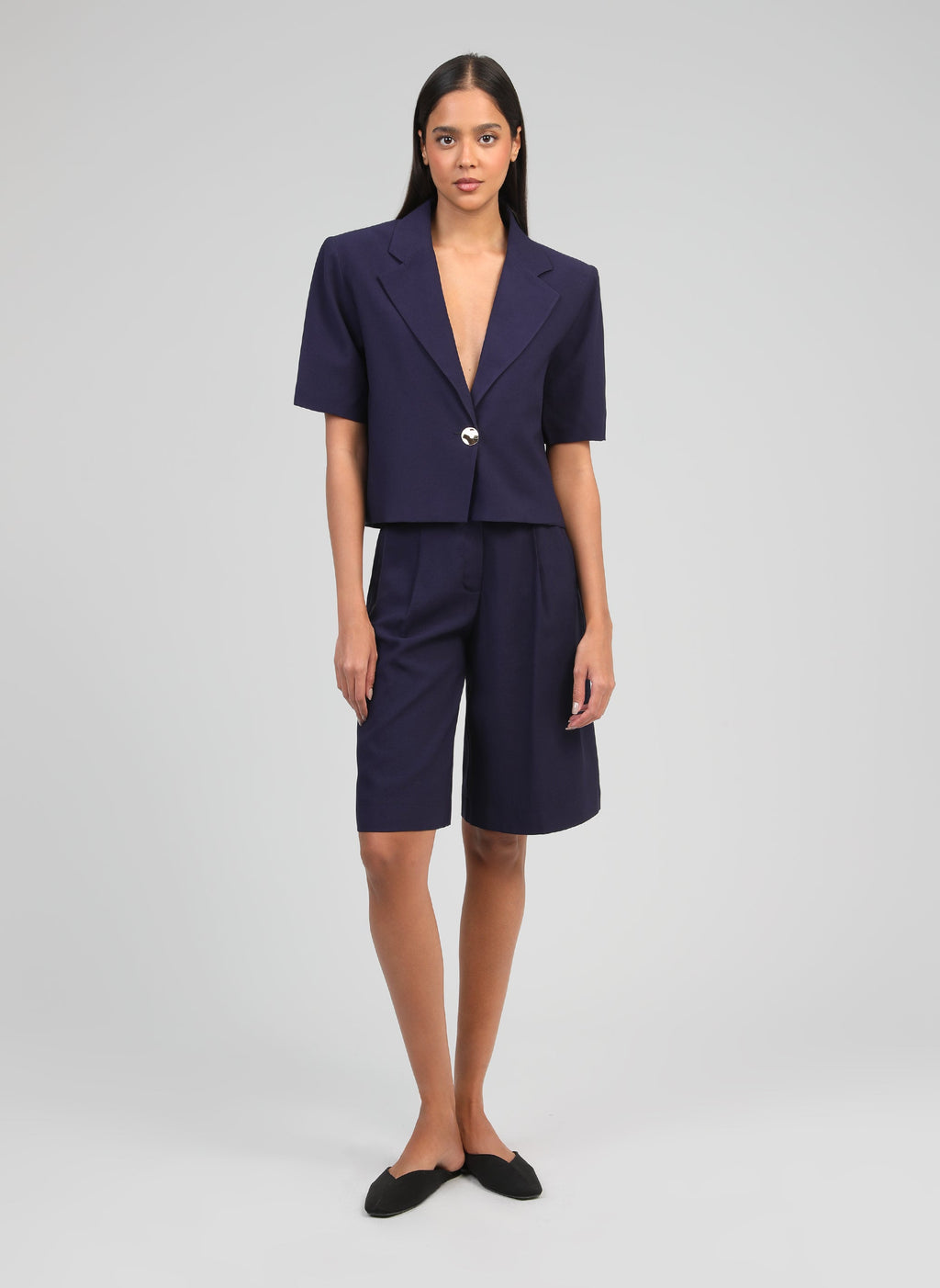 An'ge – Bermuda Pasky Marine, Model im Set aus kurzem Blazer und marineblauen Bermudas