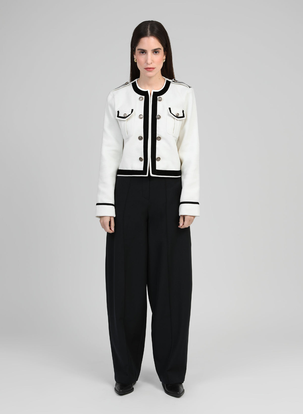 An'ge – Pantalon Pavila Noir, modell klädd i vit och svart jacka och svarta byxor