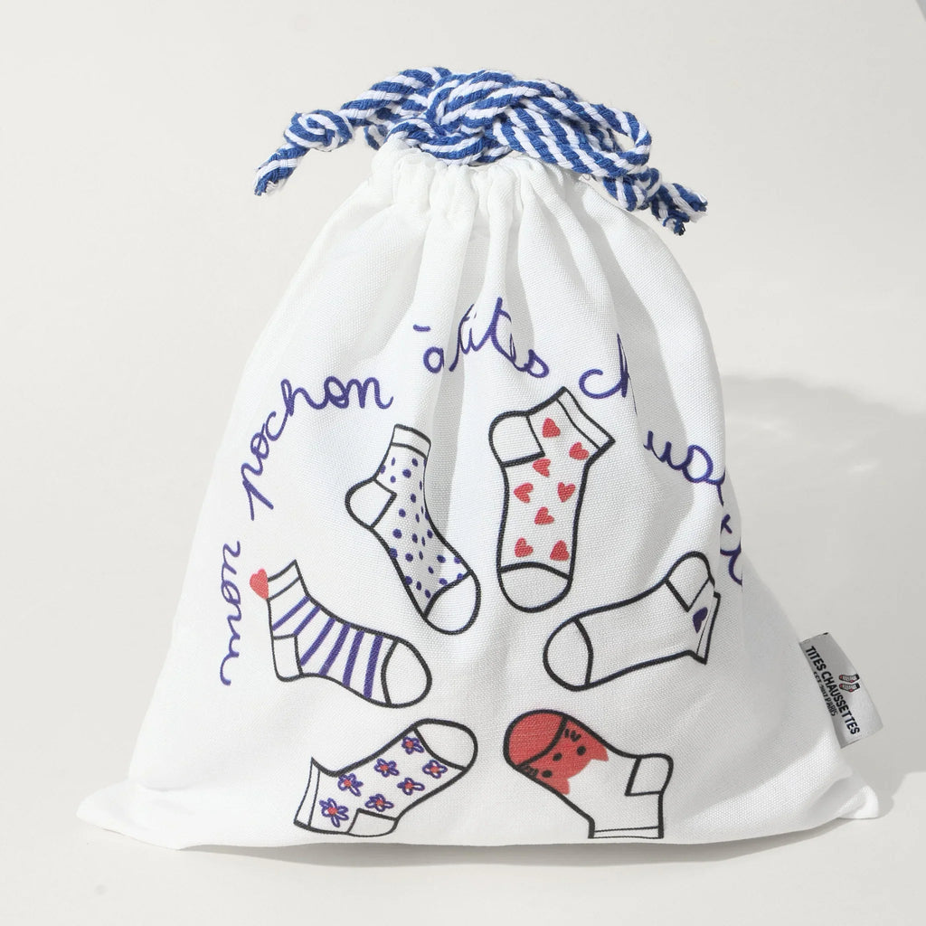 Pochon coton pour ranges ses Tites Chaussettes. Fond blanc, imprimé chaussettes à motifs bleu/rouge. Fermeture par lien coulissant blanc/bleu. 