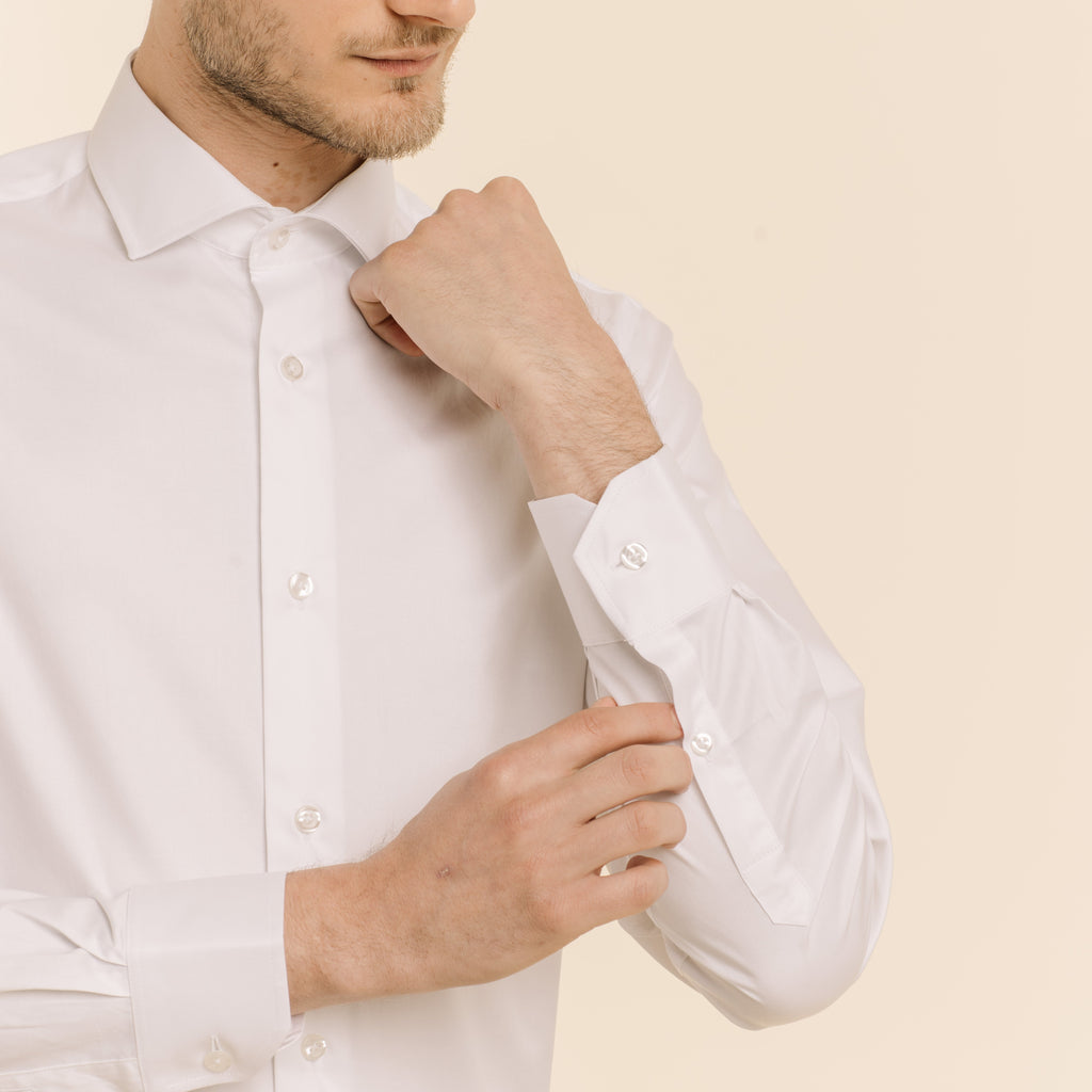 Hast – Chemise En Twill Double Retors Blanche, homme en chemise blanche, ajustant sa manche, vue de trois-quarts