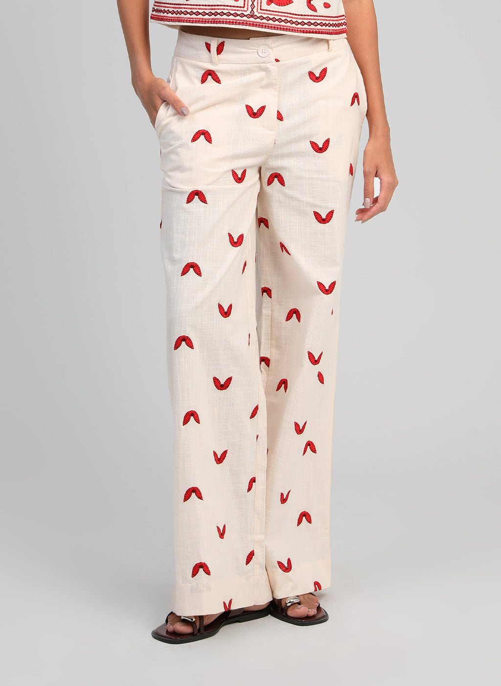 An'ge – Pantalon Romila Ecru, ecru wijde broek met rode motieven van voren gedragen door een model