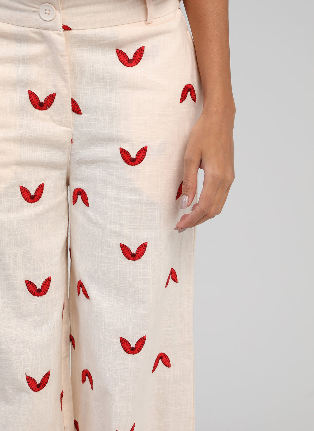 An'ge – Pantalon Romila Ecru, beige broek met rode motieven gedragen door een model