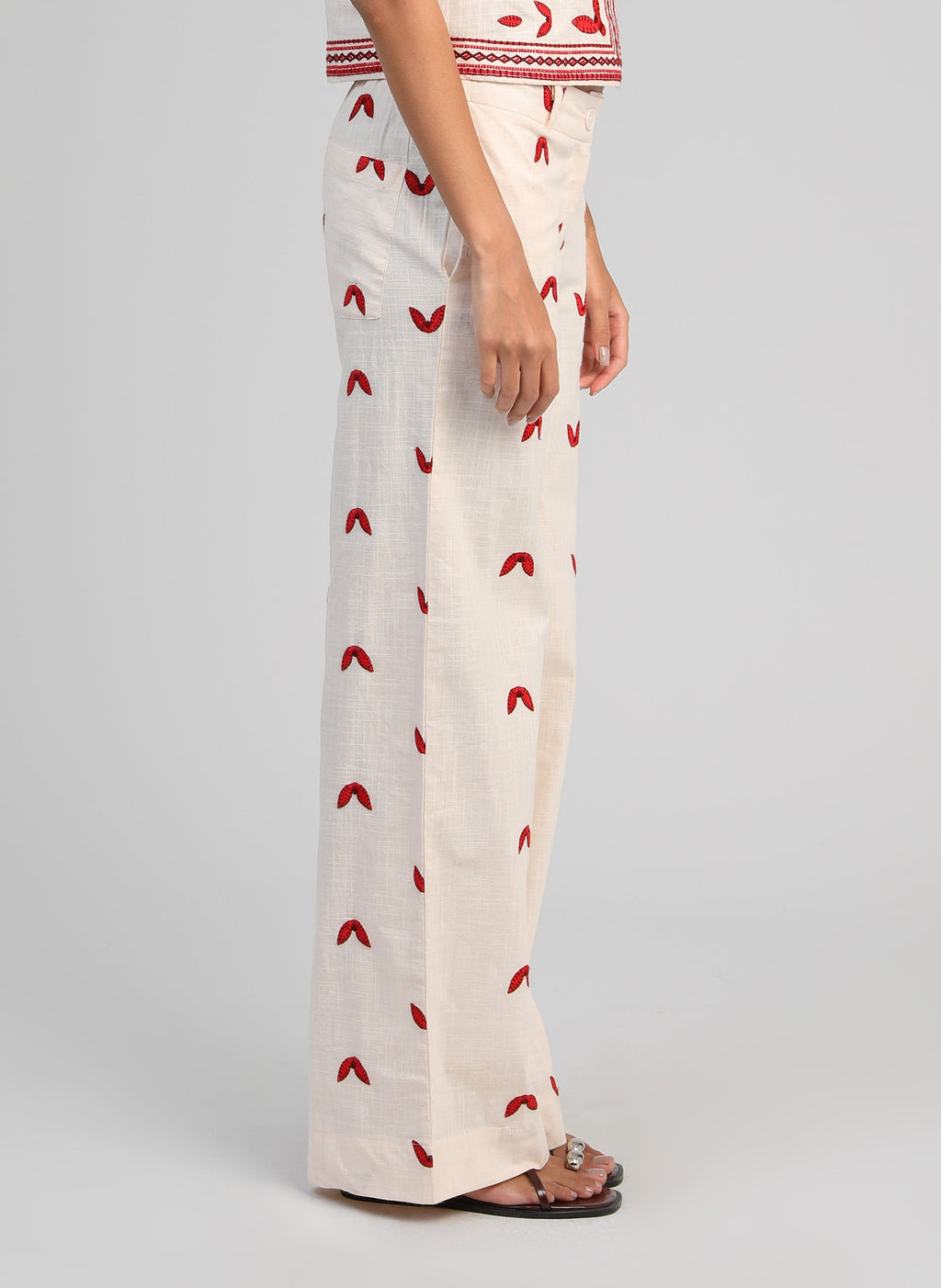 An'ge – Pantalon Romila Ecru, gebroken witte broek met rode motieven gedragen door een model, zijaanzicht